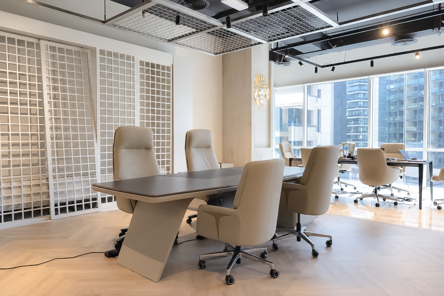 Board table, cream leather chairs, and full-height windows