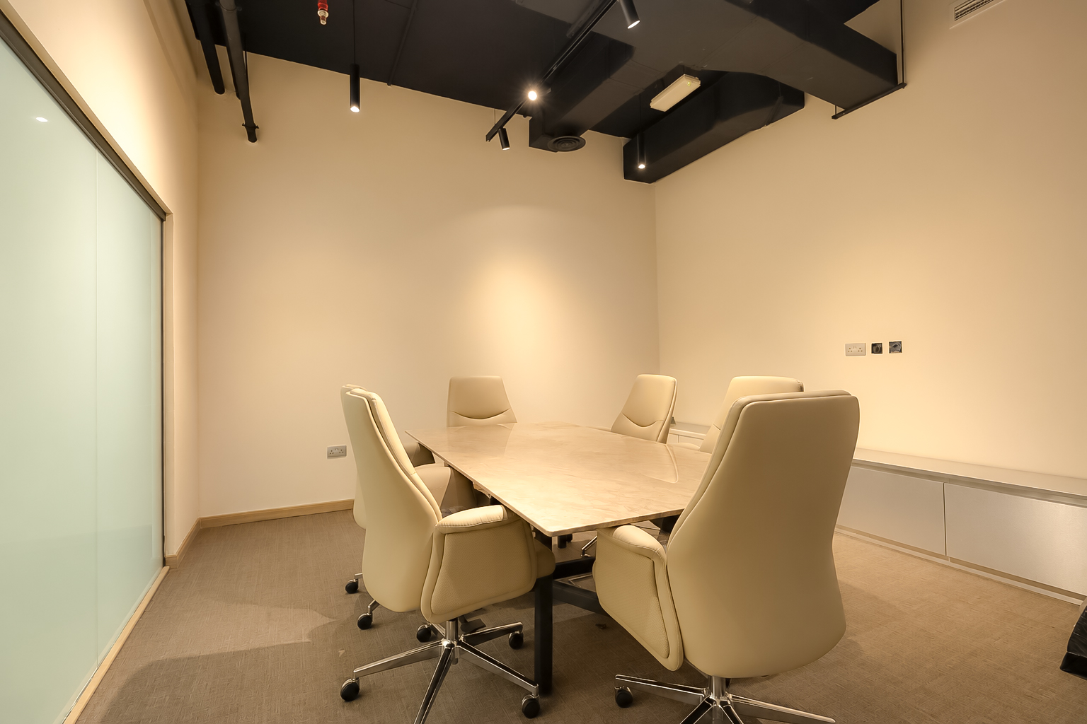 Meeting room with stone table and cream leather chairs