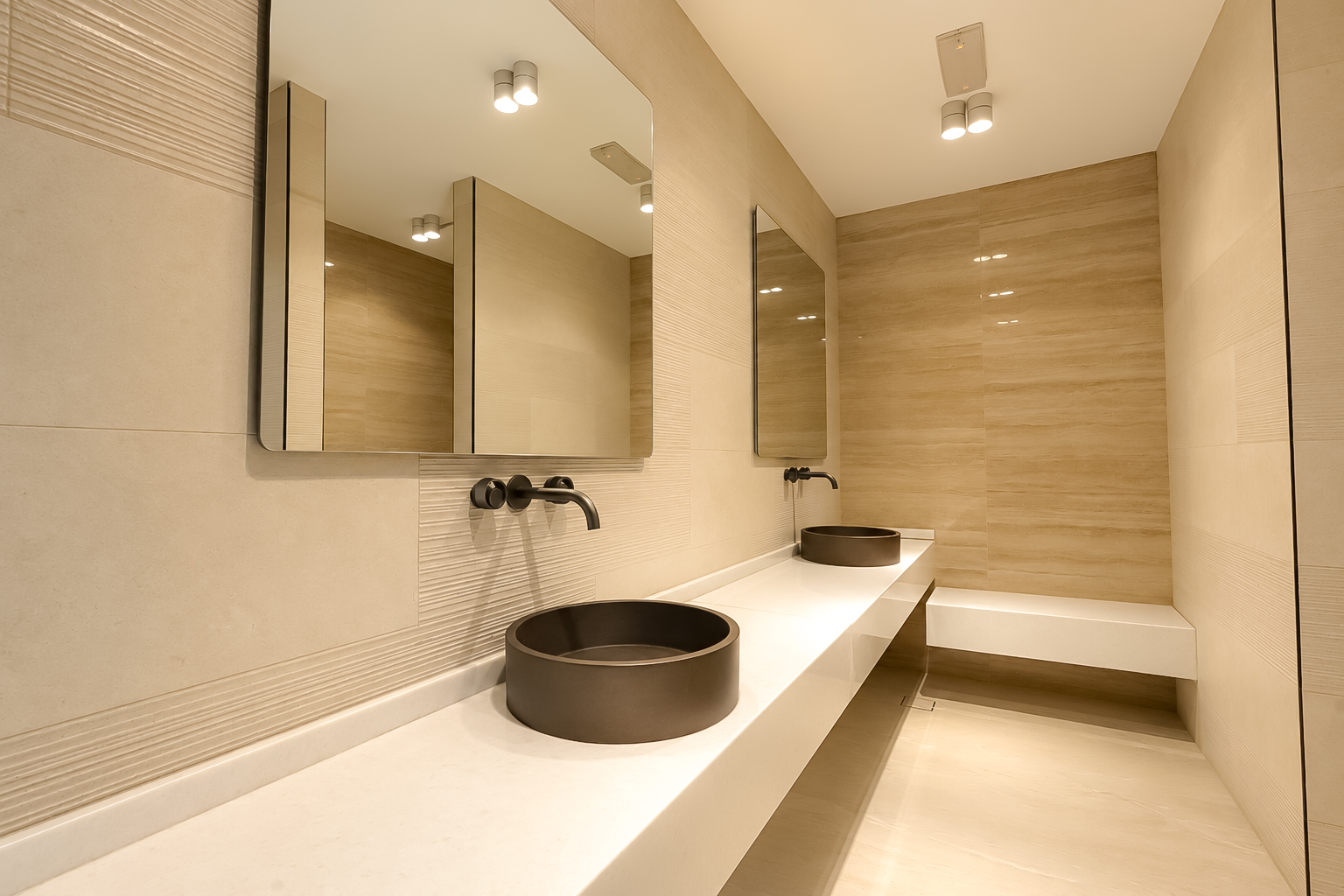 Stone washroom with vessel basins and wall-mounted taps